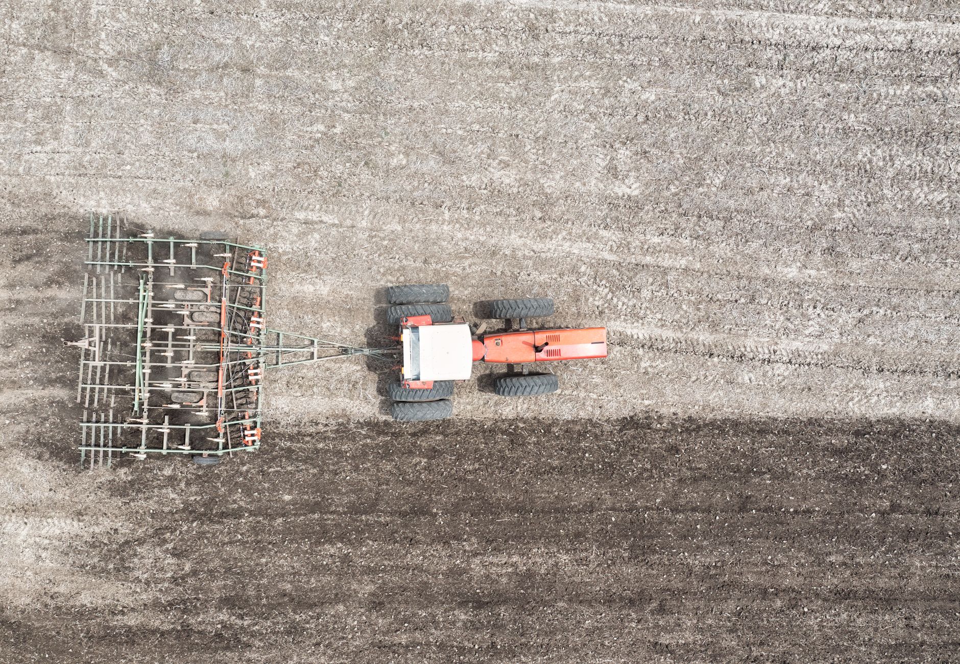 Aerial photograph of a tractor plowing a rural field in Minnesota, showcasing agricultural practices.